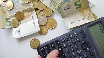 Geld und Taschenrechner auf einem Tisch